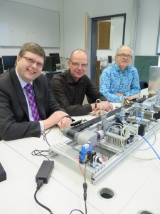 Bernd Jotzo, Andreas Stockhausen (beide iSAM) und Lehrer Peter Klatte (v.l.n.r.) präsentieren das Förderband, mit dem die Schulgruppen arbeiten.